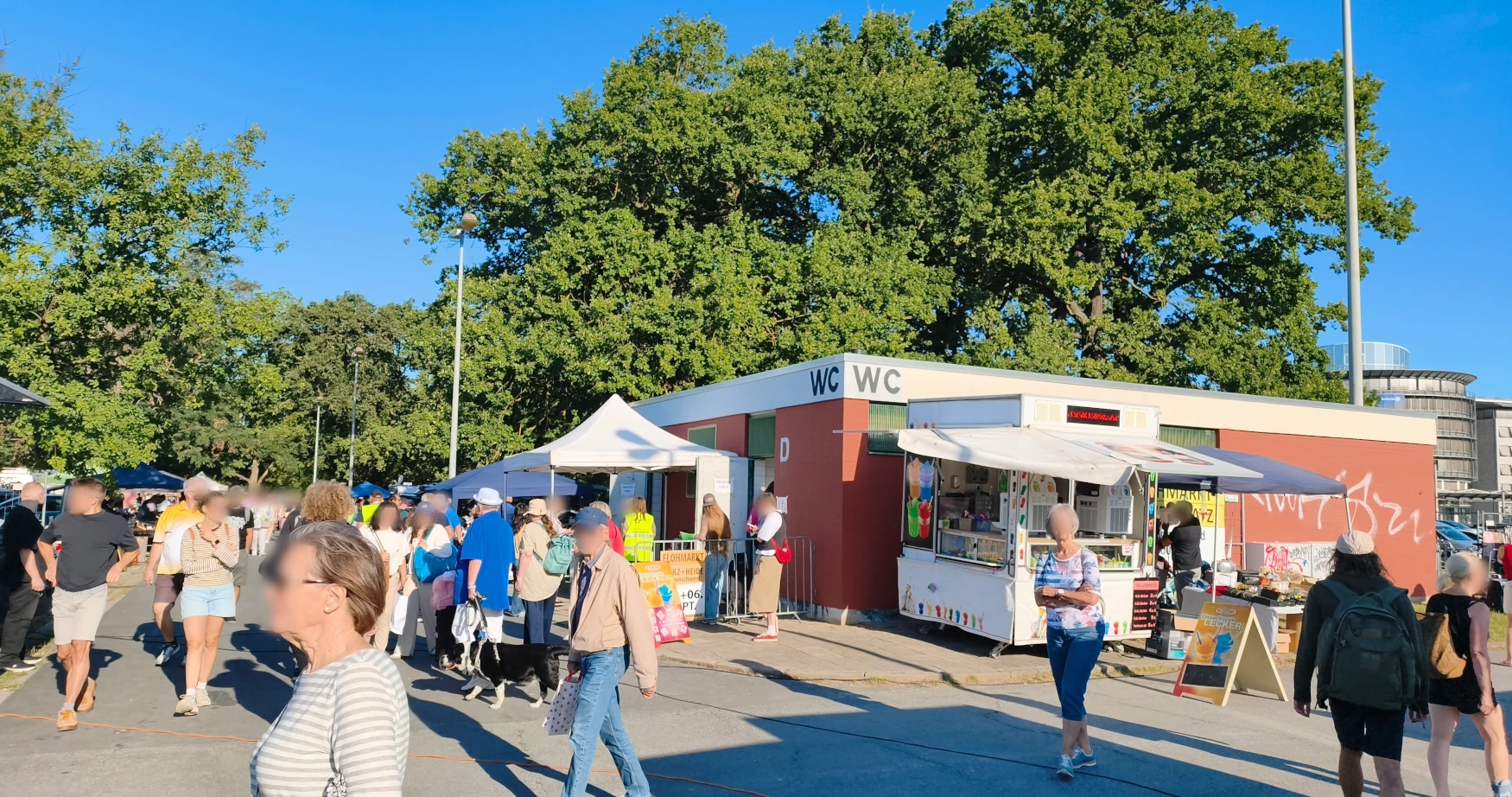 Festes Toilettengebäude mit WC-Beschilderung auf dem Flohmarktgelände